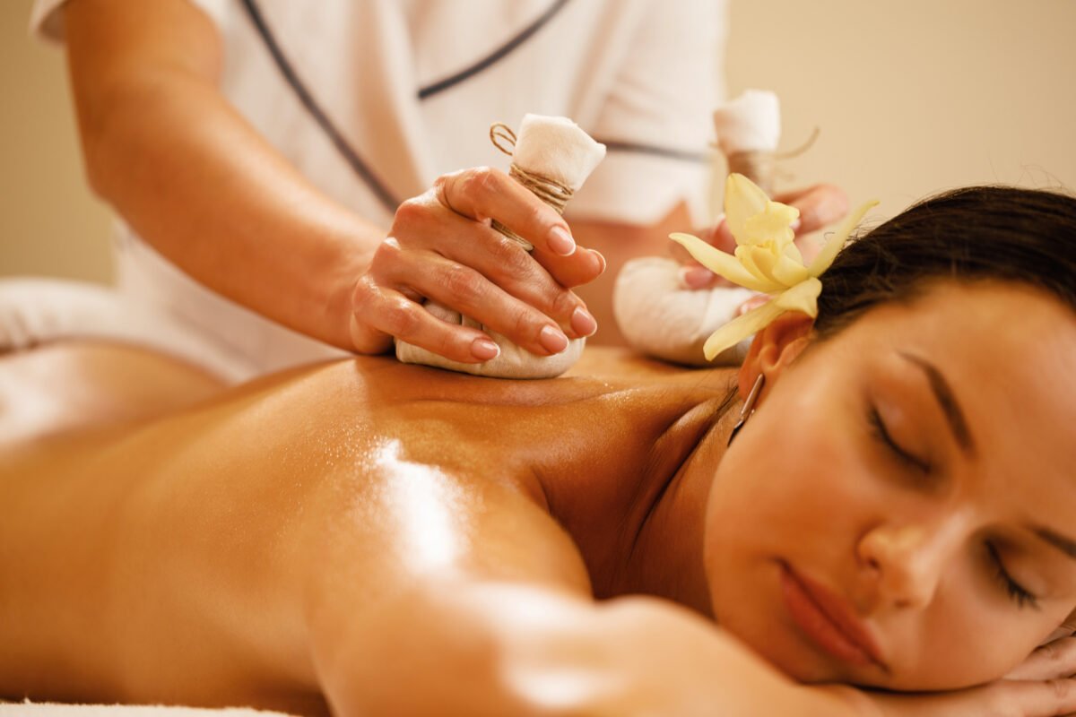 closeup relaxed woman getting back massage with herbal balls health spa